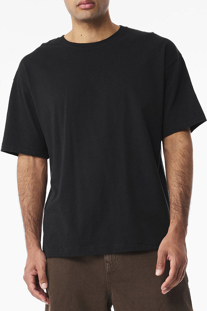 Man wearing a black t-shirt and brown pants on a white background